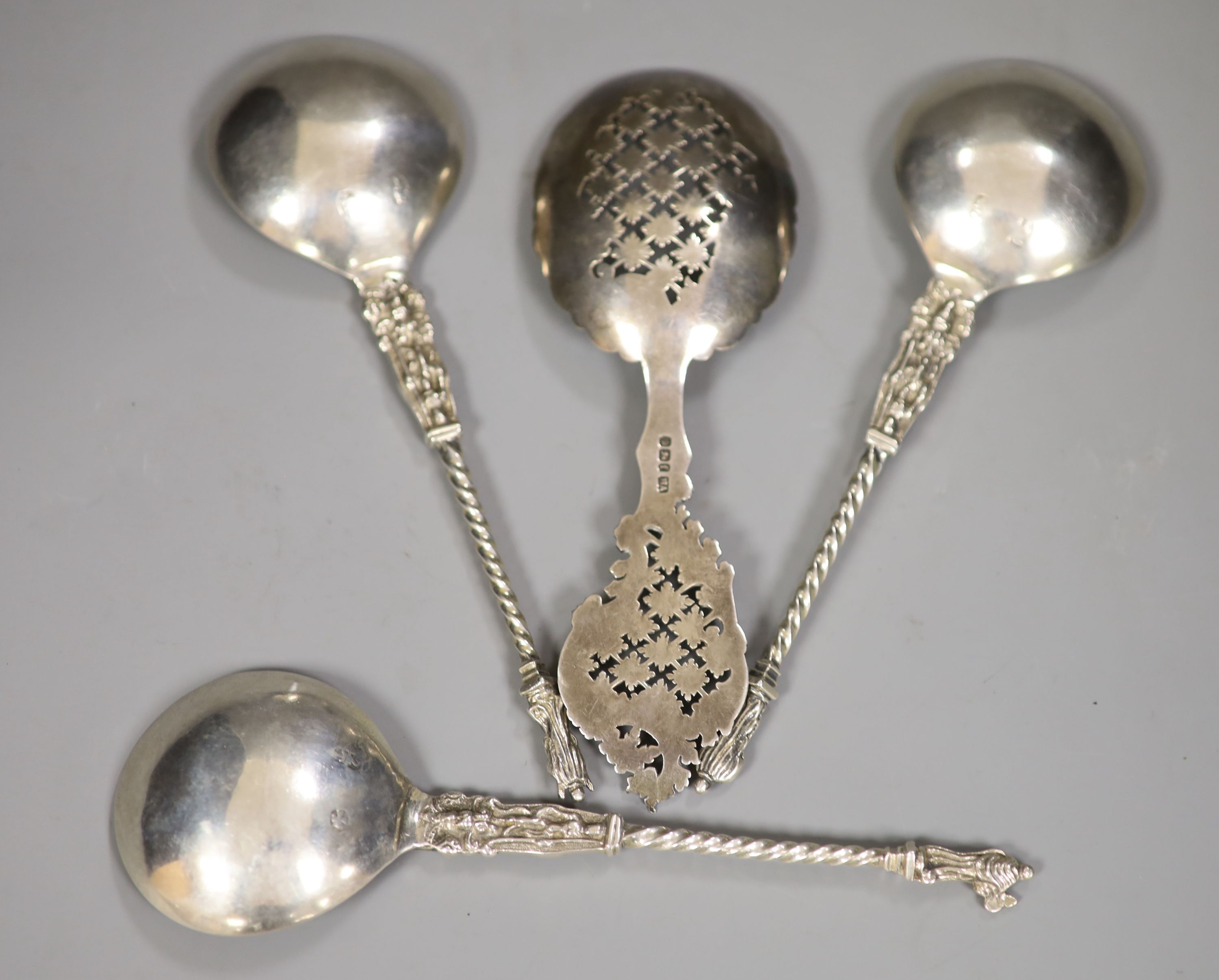 A late Victorian ornate pierced silver sifter spoon, Sheffield, 1898, 17.1cm and three continental apostle spoons